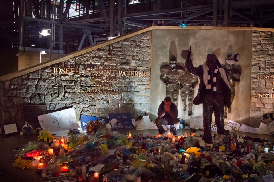 A student cries at the makeshift memorial statue for Joe Paterno, near Beaver Stadium